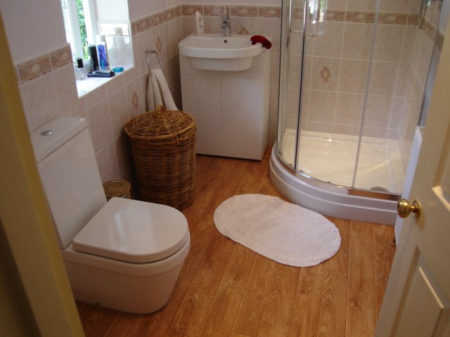 Toilet, sink, shower cubicle in finished bathroom installation