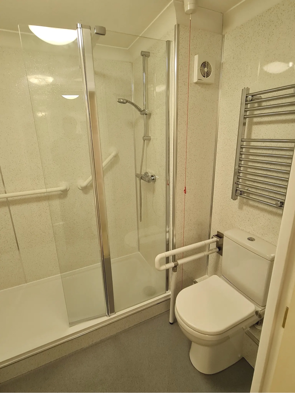 Toilet next to walk-in shower in finished bathroom